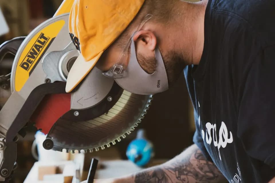 Skilled carpenter cutting wood — carpentry services in Deira by Top Fixers