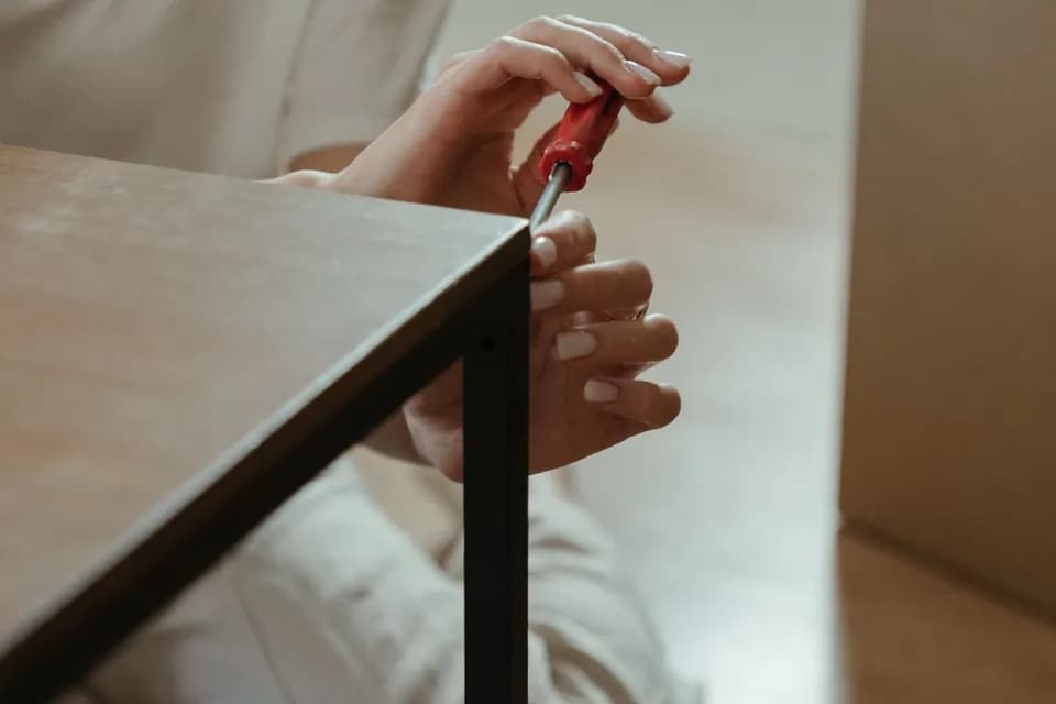Flat-pack furniture being assembled with hand tools in a Jumeirah Lake Towers (JLT) apartment
